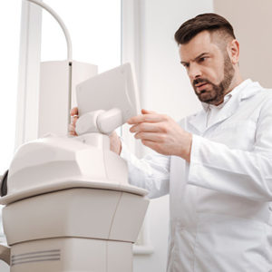 Doctor examining scanning equipments screen and concentrating