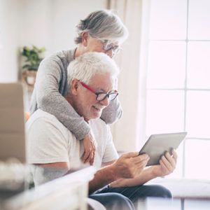 Happy elderly couple looking at tablet device together